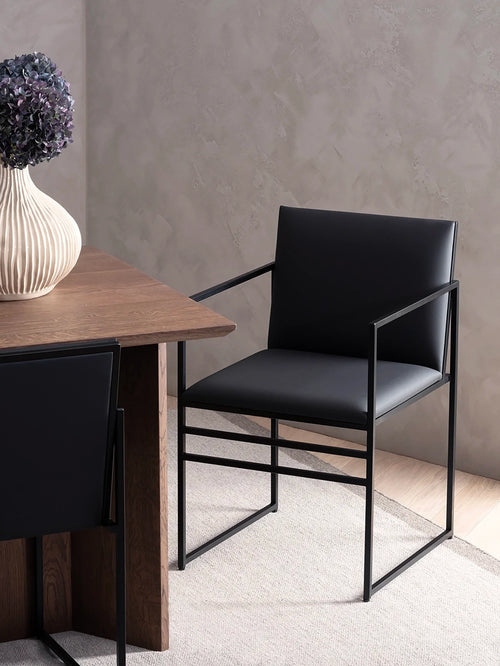 Dining chair Sella in black leather with a sleek black frame, perfect for modern dining spaces.
